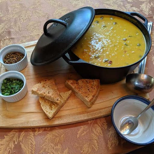 bowl and pot of soup with bread