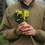 man holding a bouquet of yellow flowers