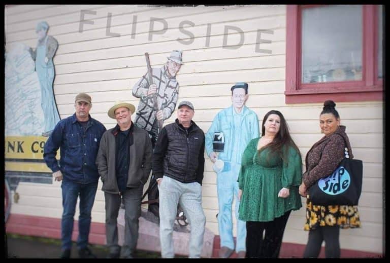 group of men and women standing in a row outside with the word flipside above their heads