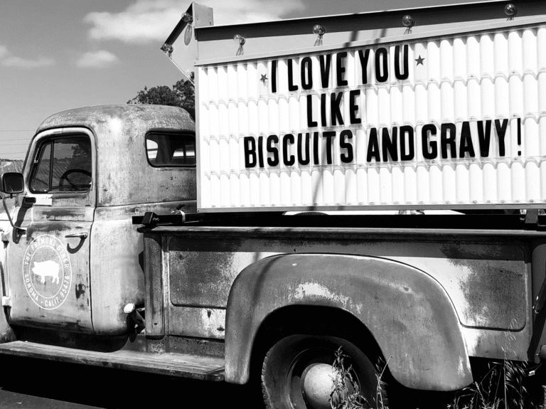 old pickup truck with a sign in the bed that reads I love you like biscuits and gravy
