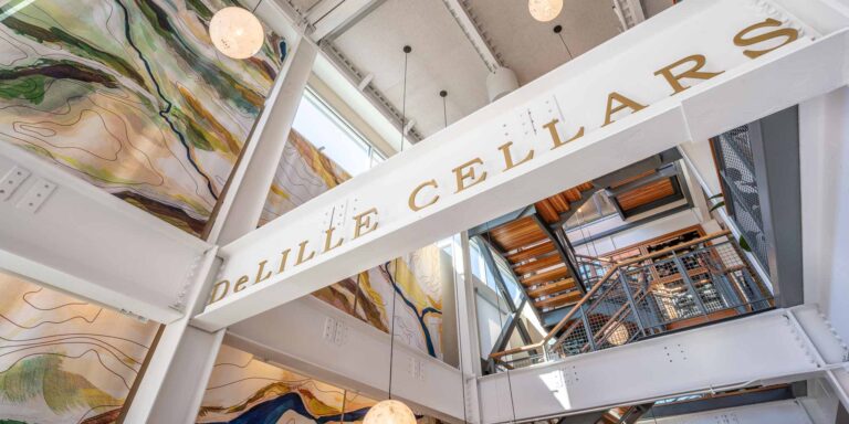 I-Beams across a ceiling painted white with DeLille Cellars embossed in gold