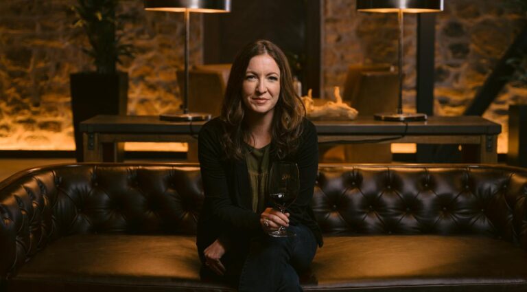 woman sitting on a couch holding a glass of wine