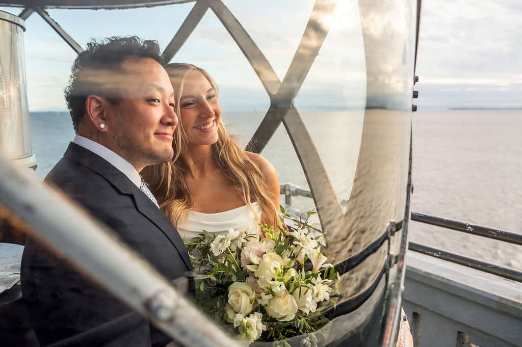 couple looking through widow at top of lighthouse